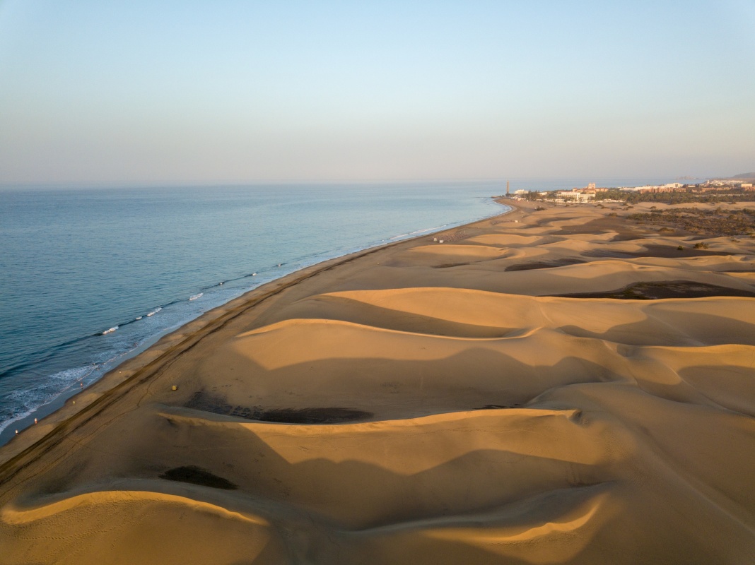 Dunas de Maspalomas en Gran Canaria, con luces doradas reflejadas en la arena